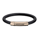 Braided black leather bracelet with a rose-gold clasp engraved 'CHOPARD' on a black background.