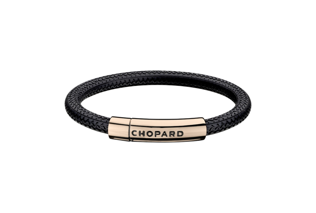 Braided black leather bracelet with a rose-gold clasp engraved 'CHOPARD' on a black background.