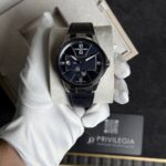 Luxurious blue-dial wristwatch with Roman numerals and subdial, held by a gloved hand in a presentation box.