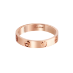 Rose-gold Cartier Love ring with signature screw motifs around the band, on a black background.