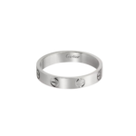 Close-up of a silver Cartier ring with a smooth band and circular cut-out accents, partially visible against a dark background, with 'Cartier' inscription on the inner edge.