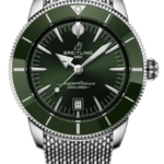 Breitling SuperOcean watch with green bezel, stainless steel mesh bracelet, dark green dial, date at 6, 200m water resistant.