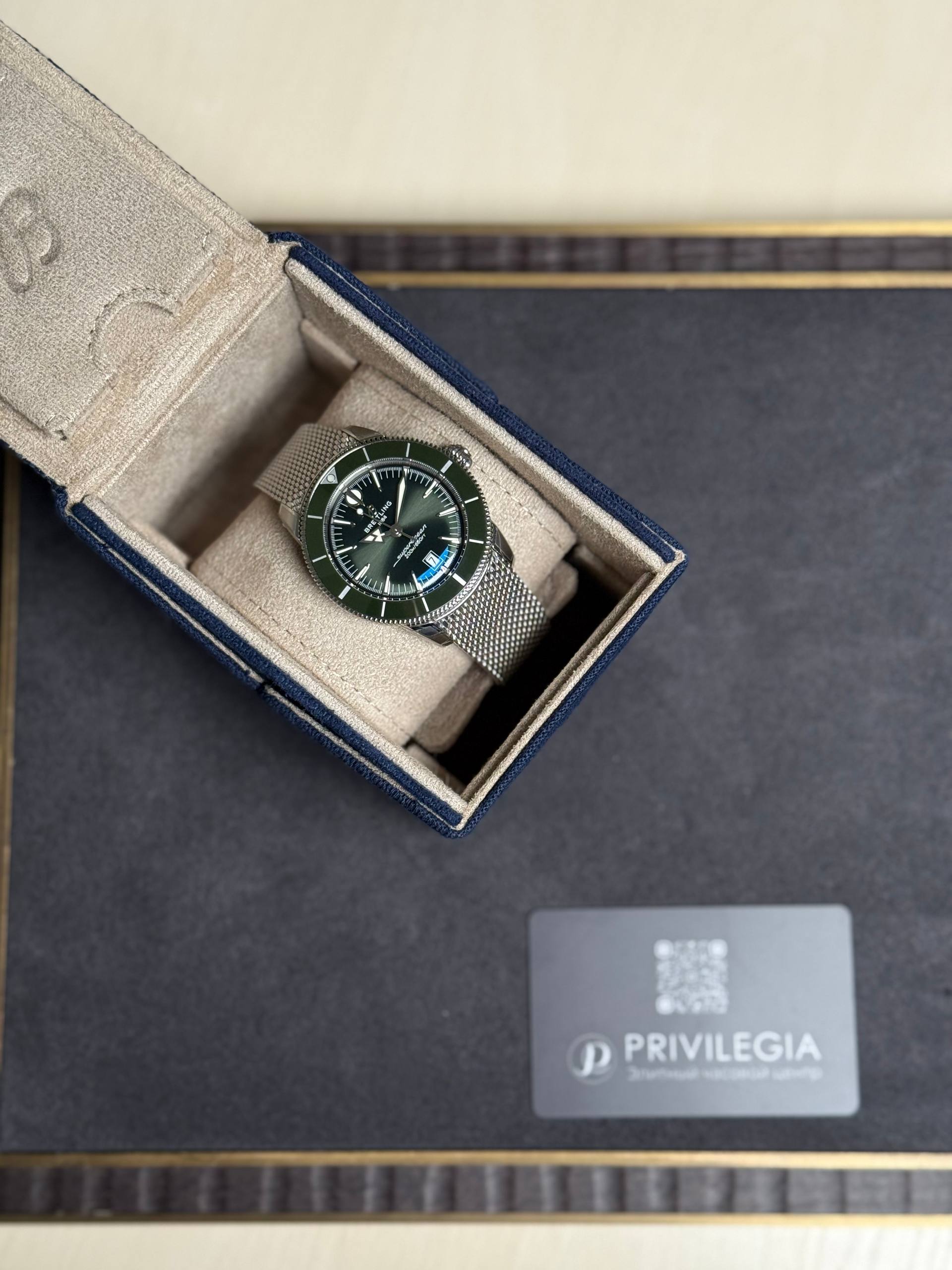 Breitling wristwatch in a beige suede presentation box with a green dial and date window