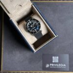 Breitling Superocean watch with black dial and mesh bracelet in a beige padded box.