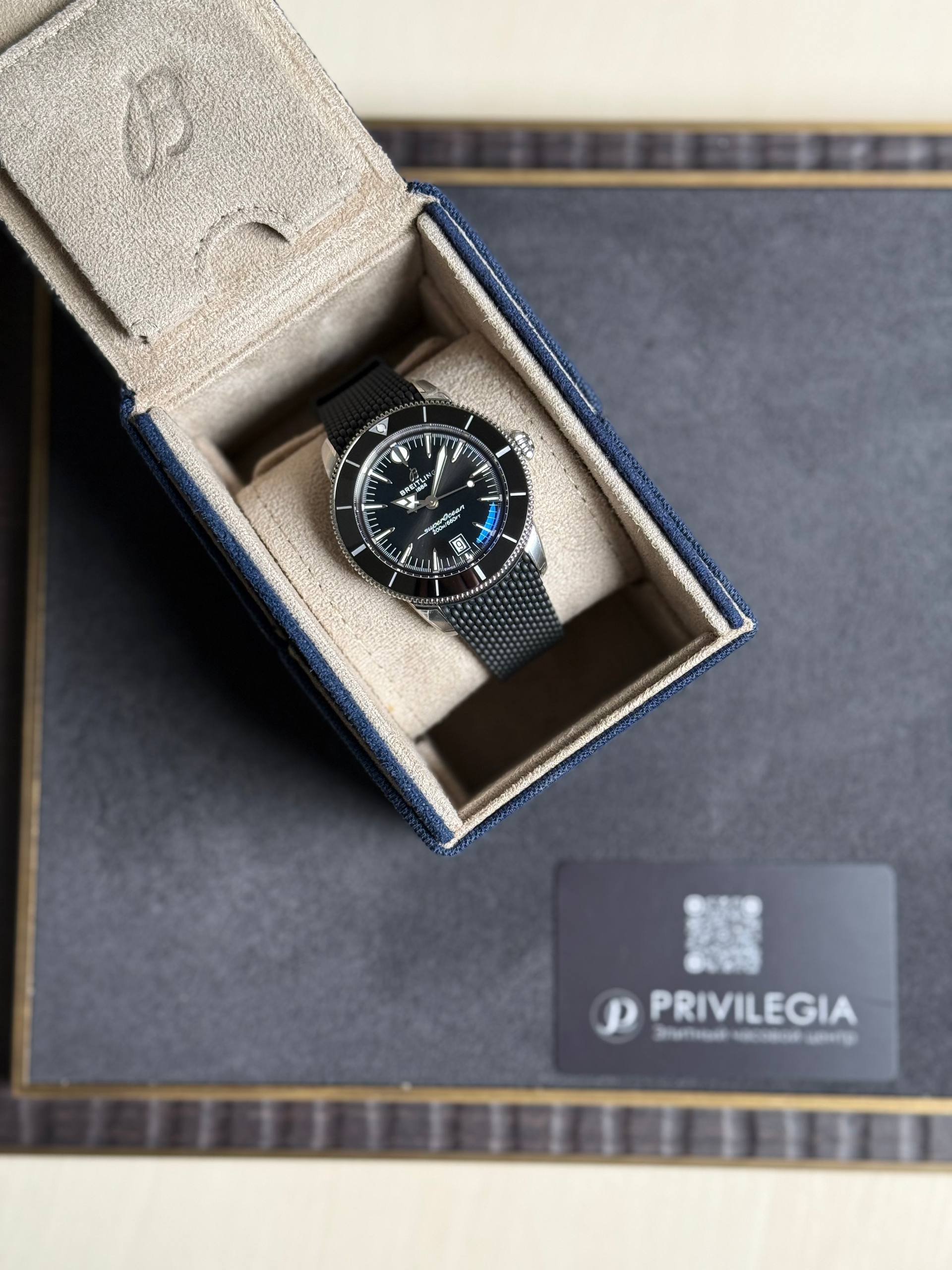 Breitling Superocean watch with black dial and mesh bracelet in a beige padded box.