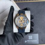 Skeleton gold-tone wristwatch with a blue perforated strap resting on a display cushion, Ulysse Nardin branding visible on the dial.