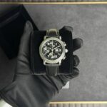 Chronograph wristwatch with black dial and leather strap held in a black presentation box