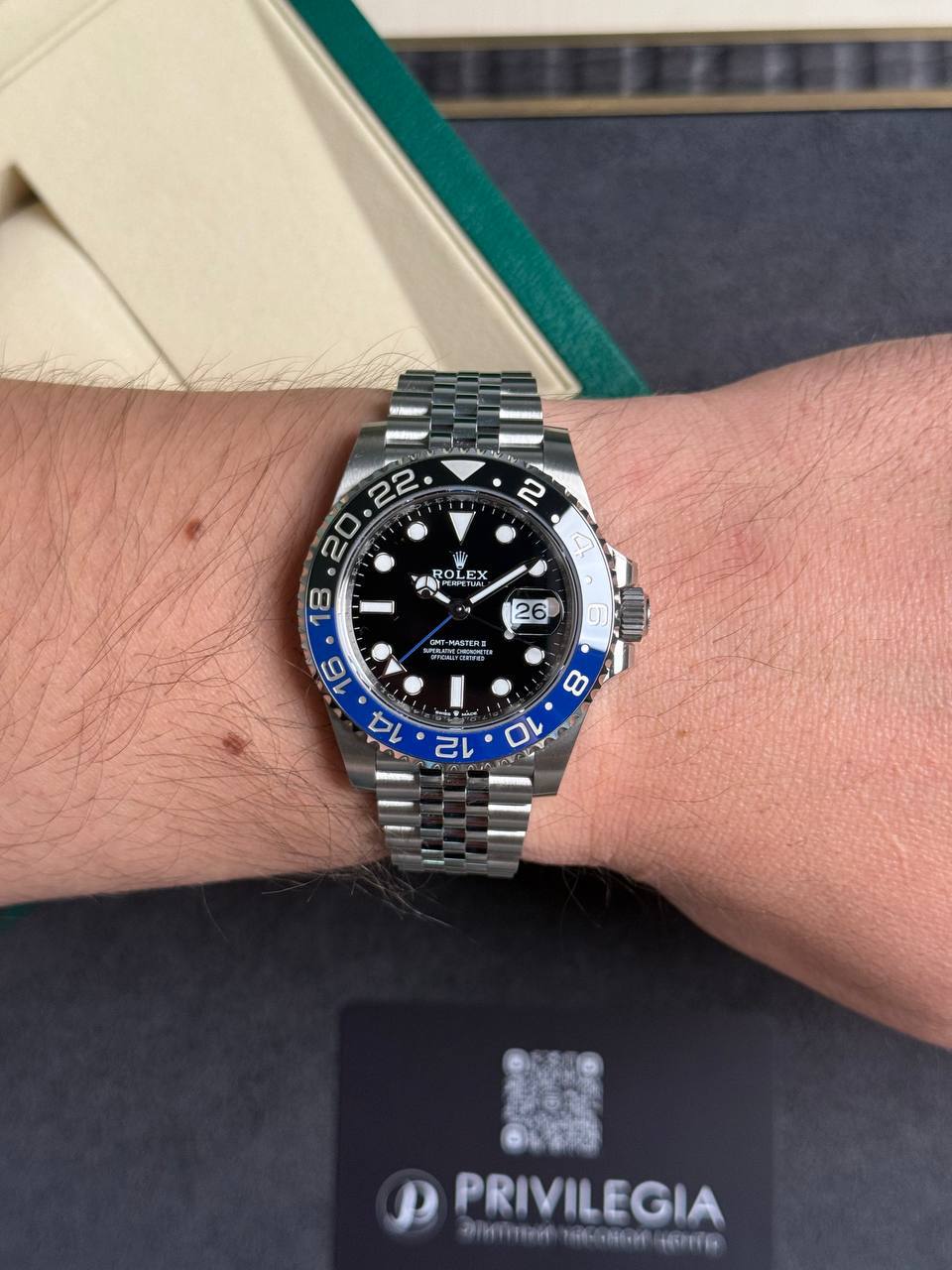Wrist wearing a stainless steel Rolex GMT-Master II with a black dial and blue/black bezel, date window at 3 o'clock.