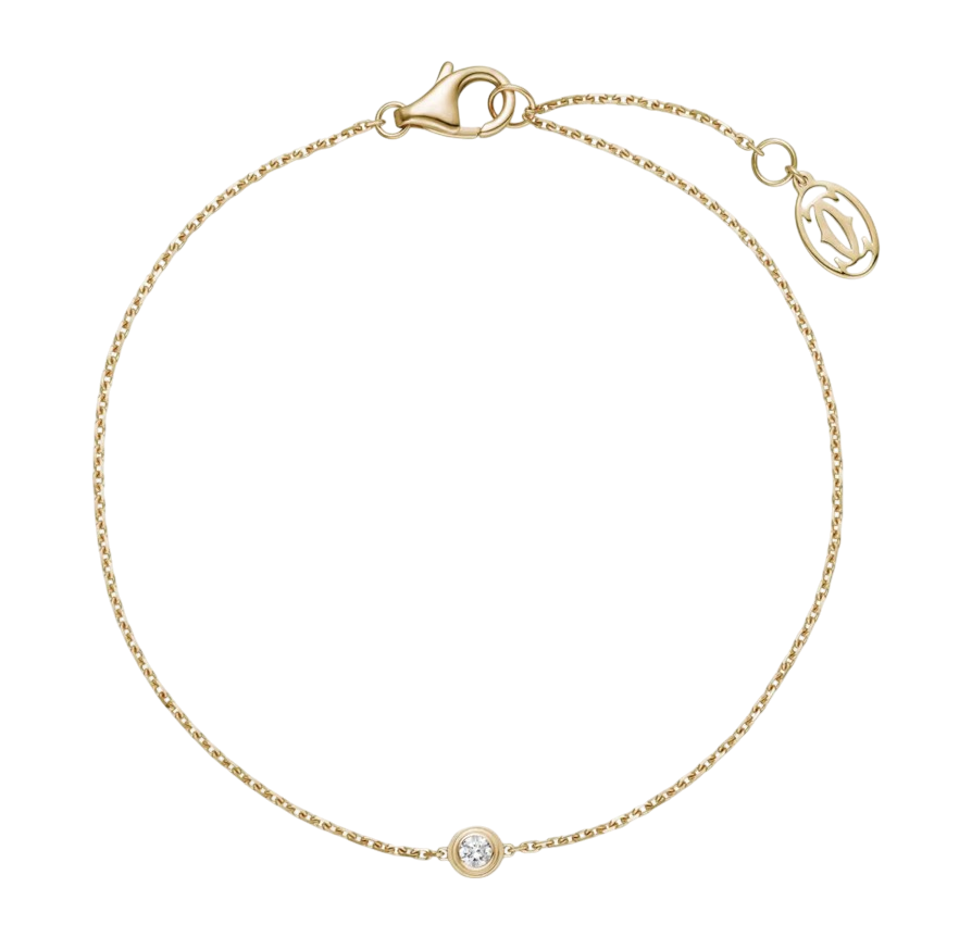Gold bracelet with a small bezel-set diamond at the center on a thin chain against a black background, jewelry product image.