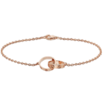 Rose gold chain bracelet with an interlocking ring clasp on a black background.