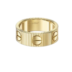 Gold Cartier ring with a ribbed band and screw-head motifs.
