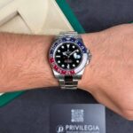Silver Rolex GMT-Master II on a wrist with a blue-red Pepsi bezel.