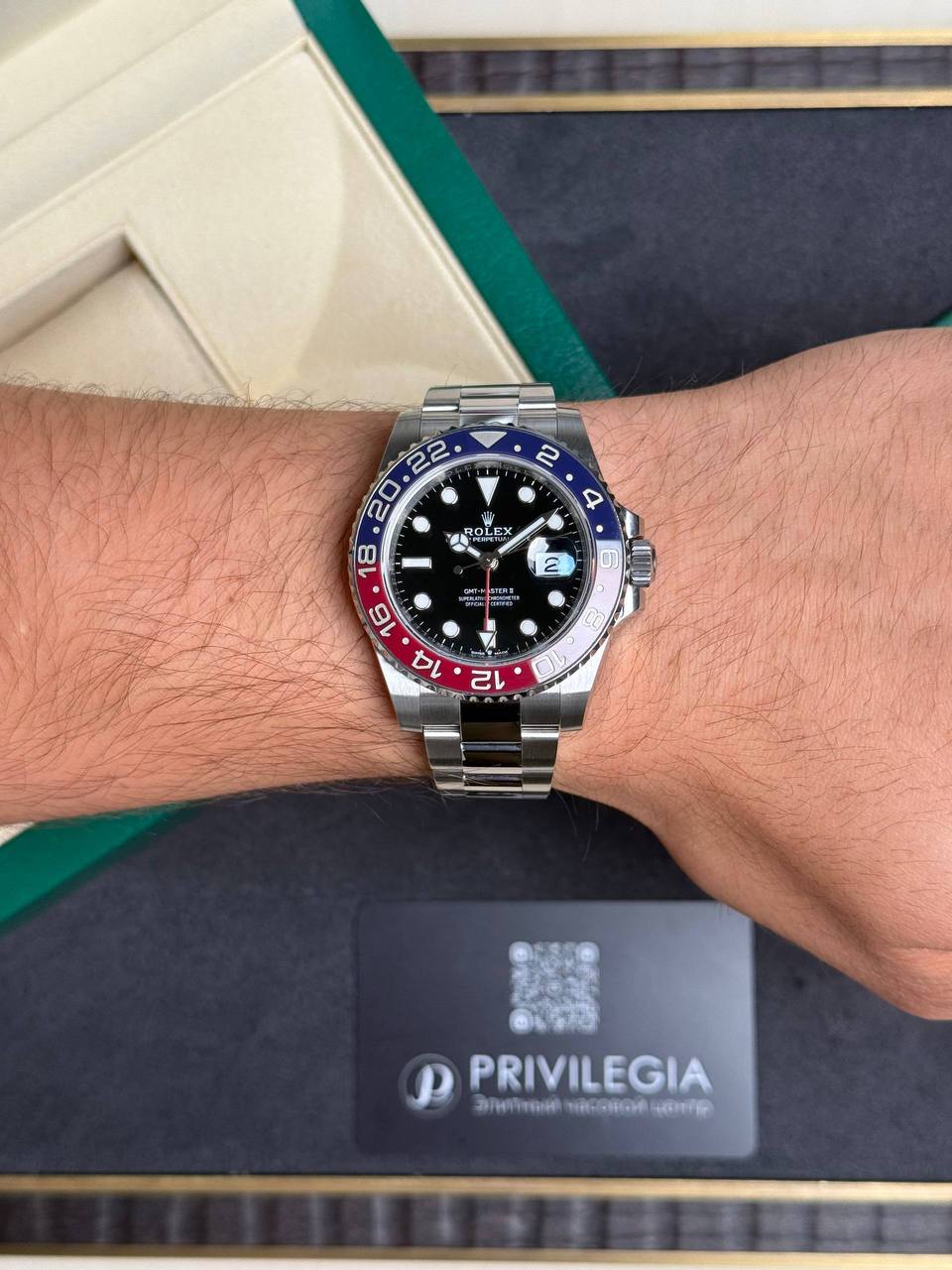 Silver Rolex GMT-Master II on a wrist with a blue-red Pepsi bezel.