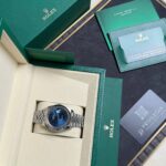 Rolex watch in beige inner box with green outer packaging and accompanying certificates and cardholders nearby