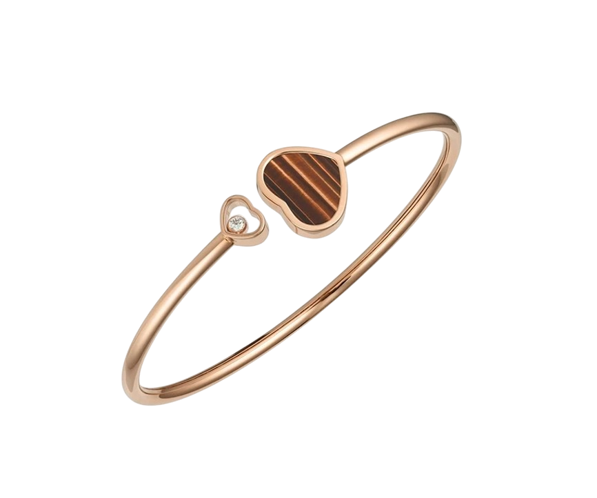 Rose gold bracelet with two heart charms, one small diamond-studded, another striped brown inlay heart
