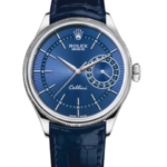 Blue dial Rolex Cellini wristwatch with a silver case and blue leather strap, showing a date subdial on the right and slim baton hour markers.