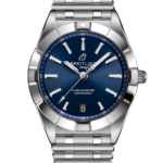 Close-up of a Breitling stainless steel wristwatch with a blue dial, silver indices, and date window at 6 o'clock on a black background.