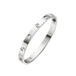 Cartier Love bracelet in polished metal with screw motifs and round diamonds along its surface.